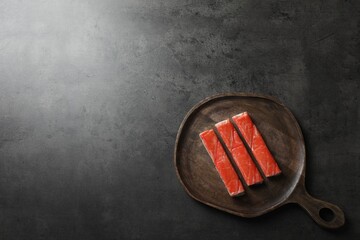 Crab sticks on grey table, top view. Space for text