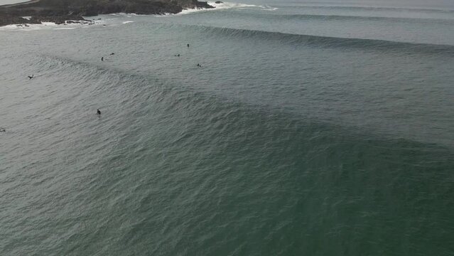 Surfers surf on waves with surfboards at the Pointe de la Torche in Brittany