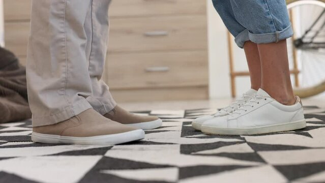 Couple, shoes and closeup of adult feet with the woman on her tiptoe to kiss her boyfriend. Romance, love and husband standing with his wife in sneakers in their home having a romantic moment.