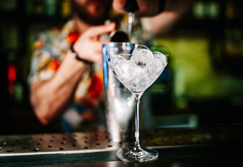 Ice cube in an empty glass on a bar counter in bar or pub