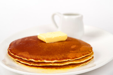 Pancakes served with butter and maple syrup