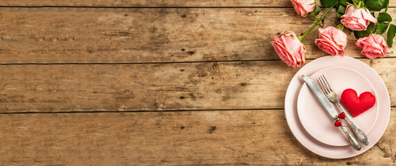 Romantic dinner table on rustic background. Love cutlery for Valentine's or Mother's day, Wedding