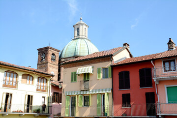 Fototapeta na wymiar The historic center of medieval origin of Gassino Torinese with the colorful houses of Piazza Sampieri and the Renaissance copper dome of the Spirito Santo.