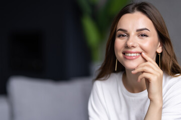 Happy young woman lying on couch and relaxing at home.