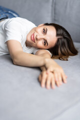 Fototapeta na wymiar Smiling young woman lying on couch. Relax