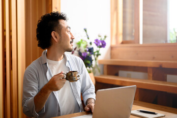 Man looking out while on computer