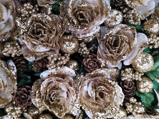 Glittery Christmas background with white and golden roses, pine cones and little golden apples, horizontal.