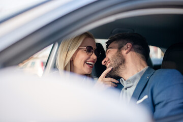 Shot of a cheerful beautiful couple driving in a car together and enjoying in the road trip.