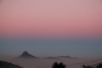 Tamil Nadu sunset on a smokey mountain. Mountain Top fog over a pink skyline,