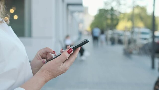 Happy Young Business Woman Walking In City Street Looking Into Mobile Phone Smartphone Screen Chatting Online In Net Smiling Answering Message In Social Media Using Gadget Device