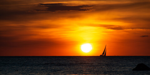 Panorama  -  Sunset over the sea with a sailing ship on the horizon