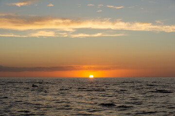 Sun on the horizon, setting over the sea