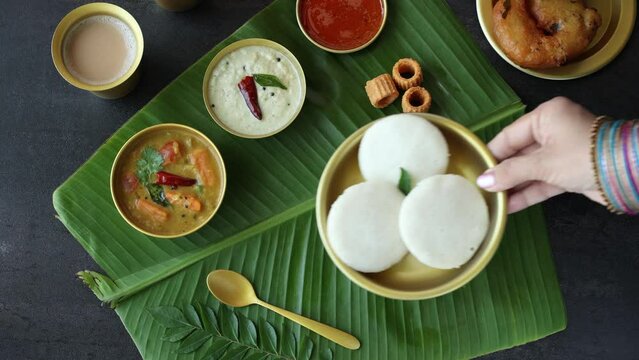 Many Idli or idly popular breakfast of Kerala South India and Sri Lanka. 4k video of healthy steamed rice cakes by steaming fermented batter of black lentils and rice coconut chutney tomato chutney.
