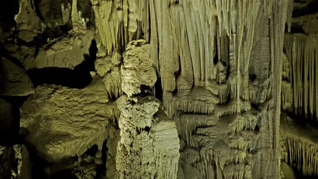 Beautiful cave with stalactites underground cavern in magic light, tilt view 4k