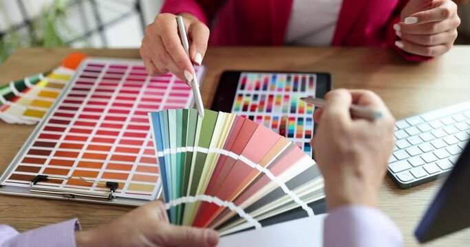 Woman designers consulting client looking at color swatch