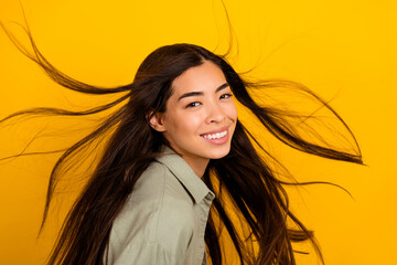 Photo of positive adorable peaceful lady toothy smile flying hairdo isolated on bright yellow color background