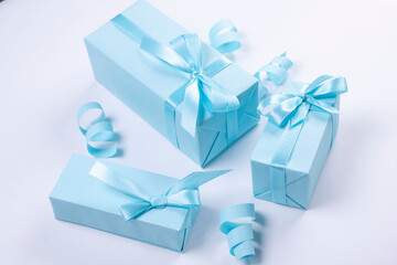  blue gift boxes with blue bows on a blue background, top view, the concept of celebrating a boy or man's birthday, a party or an anniversary or a newborn