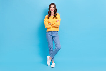 Full length photo of shiny pretty girl dressed yellow pullover standing arms crossed isolated blue color background