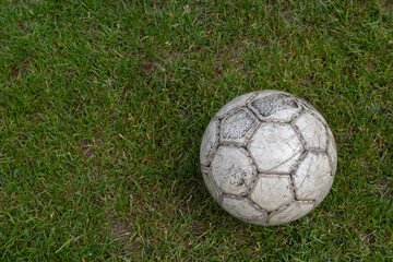 Soccer ball on green grass of football field with copy space