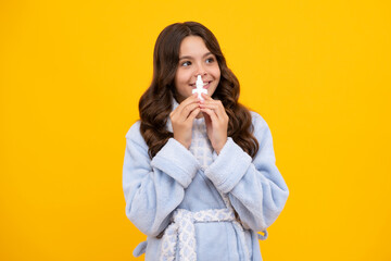 Girl hold medicine nasal spray from running nose, virus pandemic. Sick teen girl with nasal spray on yellow background.