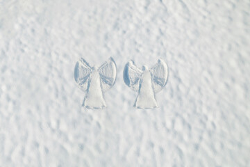 Snow two angel couple print on a snow covered land. Aerial, top view. Drone photo. Winter
