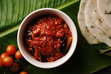 Homemade Tomato pickle Thokku or Chutney served with rice dosa- South Indian breakfast