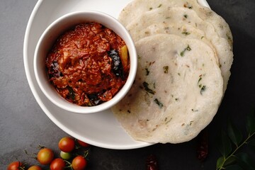 Homemade Tomato pickle Thokku or Chutney served with rice dosa- South Indian breakfast