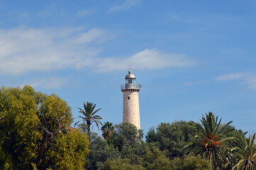 Faro de la playa de Vilanova entre árboles y palmeras