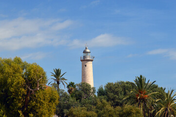 Faro de la playa de Vilanova entre árboles y palmeras