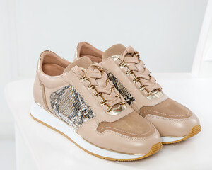 Beige stylish sneakers in a white interior. Trend of the season and photos for advertising