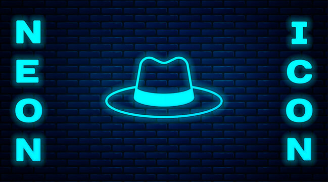 Glowing neon Man hat with ribbon icon isolated on brick wall background. Vector