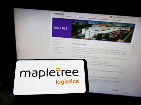Stuttgart, Germany - 09-14-2022: Person holding mobile phone with logo of Mapletree Logistics Trust Management Ltd. (MLT) on screen in front of web page. Focus on phone display.