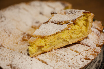 Fetta di Pastiera napoletana appena tagliata e spolverata con zucchero a velo
