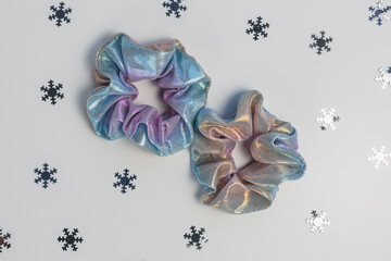 Two shiny metallic scrunchies and silver snowflakes. Winter trends