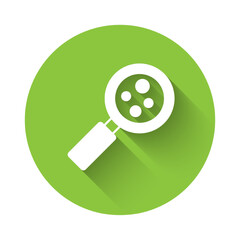 White Microorganisms under magnifier icon isolated with long shadow background. Bacteria and germs, cell cancer, microbe, virus, fungi. Green circle button. Vector
