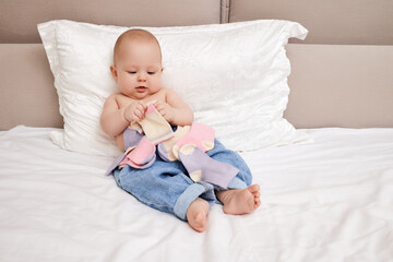 baby girl play with own socks in bedroom