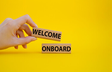 Welcome onboard symbol. Concept words Welcome onboard on wooden blocks. Beautiful yellow background. Businessman hand. Business and Welcome onboard concept. Copy space.