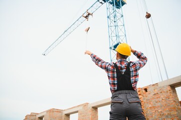 Construction worker in uniform and safety equipment have job on building. Industrial theme