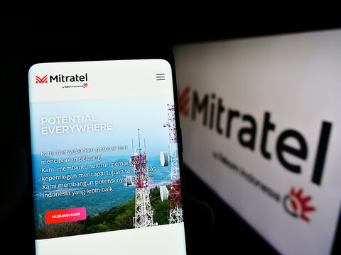Stuttgart, Germany - 09-15-2022: Person holding cellphone with website of PT Dayamitra Telekomunikasi Tbk. (Mitratel) on screen in front of logo. Focus on center of phone display.