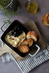 Baked camembert cheese with thyme, baguette , grapes and olive oil.