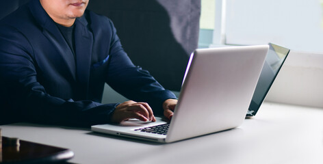 Businessman wearing a van in a suit working with a laptop computer on the desk in the office