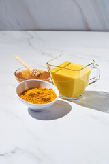 Turmeric latte with milk and honey. Elixir of health and vivacity. Traditional healthy Indian drink.