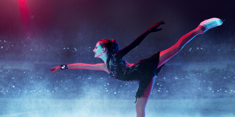Junior female figure skater wearing beautiful dress performing short program over ice arena...