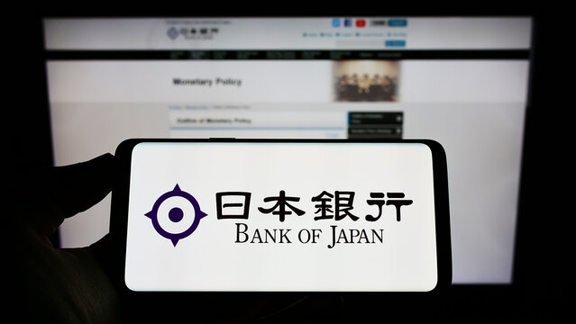 Stuttgart, Germany - 09-18-2022: Person holding mobile phone with logo of financial institution Bank of Japan (BOJ) on screen in front of web page. Focus on phone display.
