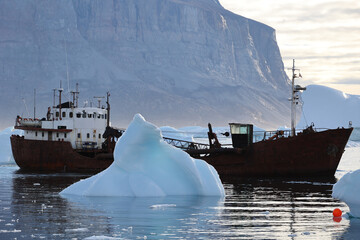 Fishing trawler amidst icebergs in the port of Uummannaq in Uummannaq fjord, Greenland, Denmark  