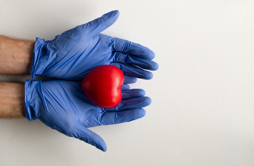 heart in hands, protective gloves, space for text.
