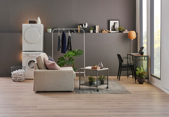 Washing and drier machine in the grey wall room background, laundry, clothe, sofa and working table style, minimalist home interior.