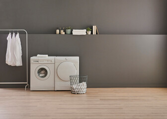 Obraz premium Washing and drier machine in the grey wall room background, laundry, clothe, sofa and working table style, minimalist home interior.