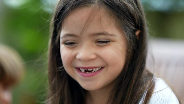Portrait of a happy little girl closeup face with missing teeths. Joygul female child toothless front tooth smiling
