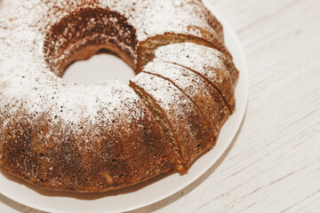 The baked dessert is a round cupcake sprinkled with powder.